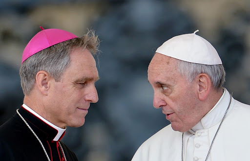 Pope Francis (R) speaks with German archbishop Georg Ganswein
