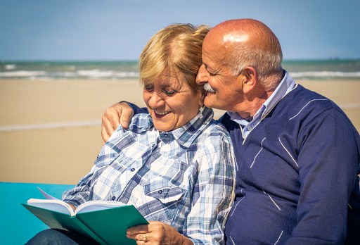 Old happy couple looking at their photo album &#8211; fr