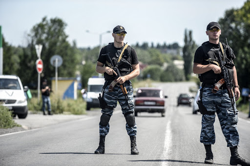 UKRAINE, Donetsk : Pro-Russian militants block the road behind Dutch and Australian forensic teams on their way to the crash site of the Malaysia Airlines flight