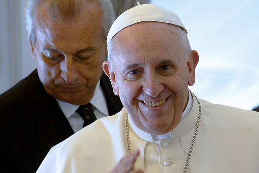 Pope Francis, smiling, gives a press conference aboard the plane carrying them back to Rome at the end of a five-day trip to South-Korea, on August 18, 2014
