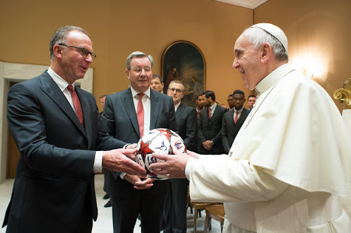 Pope Francis receiving a gift by Bayern Munich’s executive board chairman Karl-Heinz Rummenigge (L) during a private audience at the Vatican