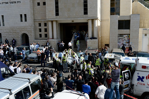 JERUSALEM, ISRAEL -NOVEMBER 18: Members of the Israeli emergency service carry the body of a synagogue attack victim