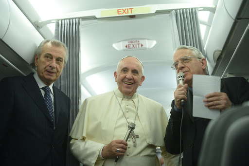 Pope Francis (C) addresses journalists aboard a plane at the end of his three day visit in Turkey, on November 30, 2014.