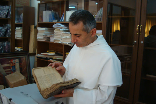 Father Najeeb Michaeel examines a manuscript