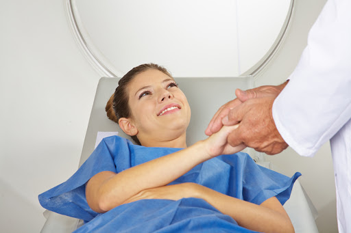 Doctor calming a young patient before MRI scan in radiology &#8211; fr