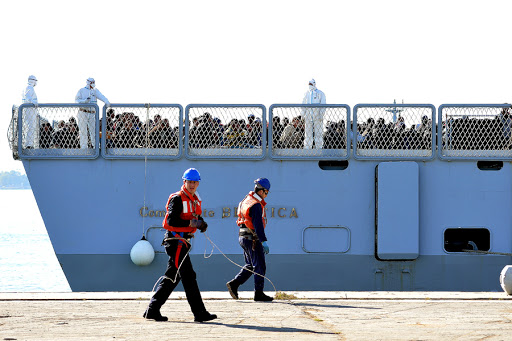 Italian naval officers stand in front of rescued migrants onboard the Italian Navy vessel Bettica &#8211; AFP &#8211; fr