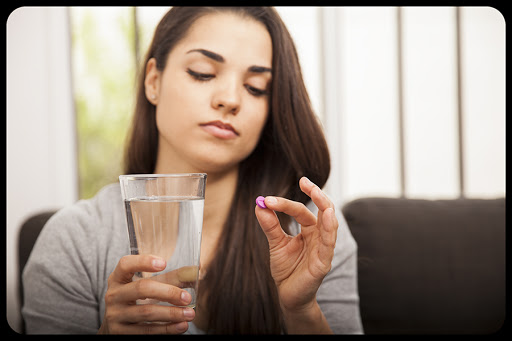 Pretty young woman holding a morning after pill © Antoniodiaz / Shutterstock &#8211; fr