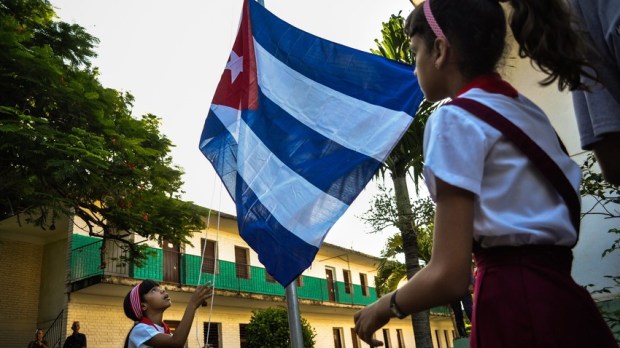 Niñas alzando la bandera cubana