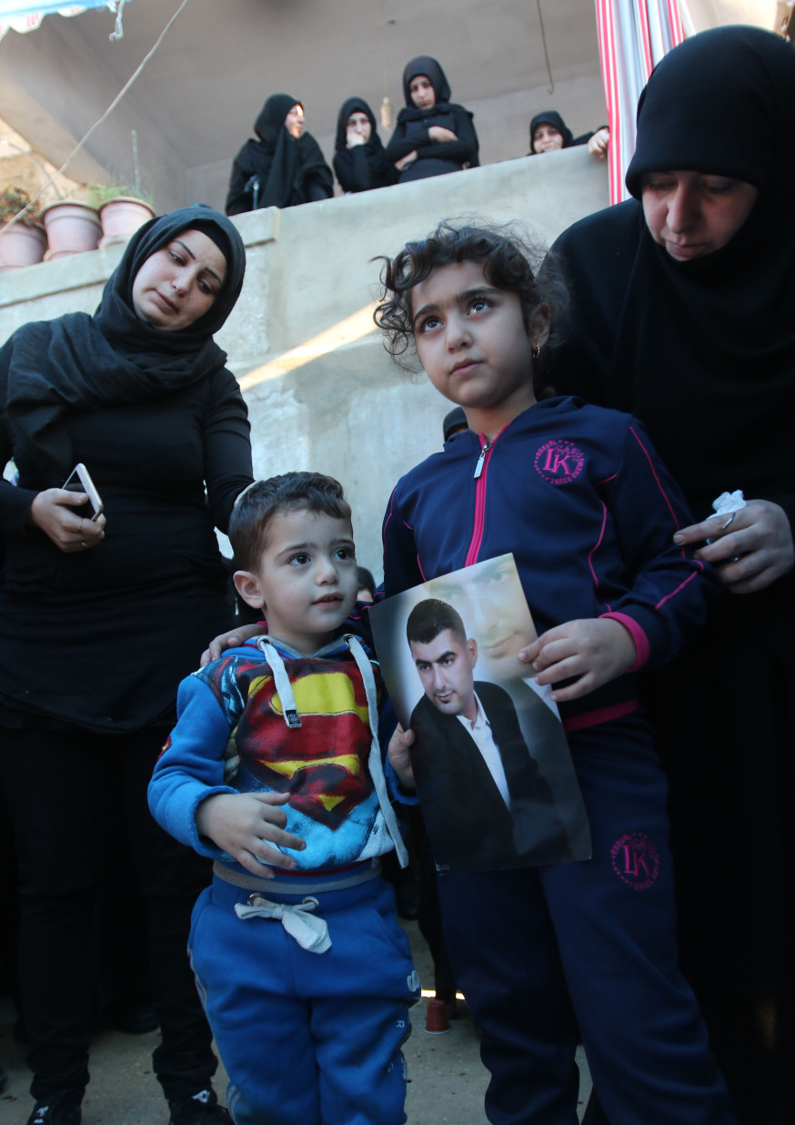 Ali et Malak, les enfants d'Adel Termos, tué dans le double attentat-suicide du quartier de Burj al-Barajneh à Beyrouth le 12 novembre 2015, portant un portrait de leur père durant ses funérailles © AFP PHOTO / MAHMOUD ZAYYAT