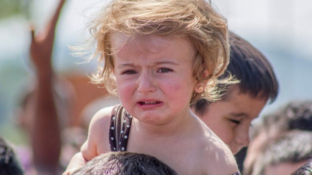 Refugee child waits with family at Greek-Macedonia border at Gergelija, Macedonia (FYROM)