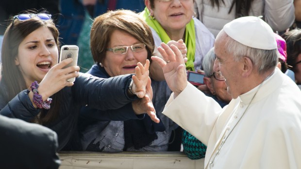A girl taking a Picture of Pope Francis
