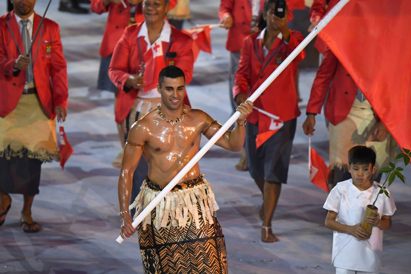 JO, RIO DE JANEIRO, BRÉSIL - 3 AOÛT :  Pita Taufatofua arbore le drapeau de son pays durant la cérémonie d'ouverture des JO. © Olivier Morin | AFP | Getty Images