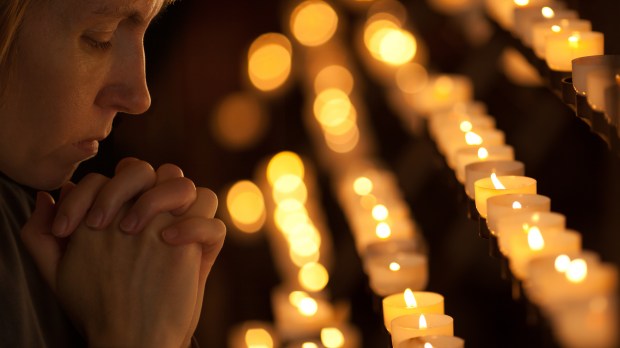 web-woman-pray-candle-light-andrey_kuzmin-shutterstock