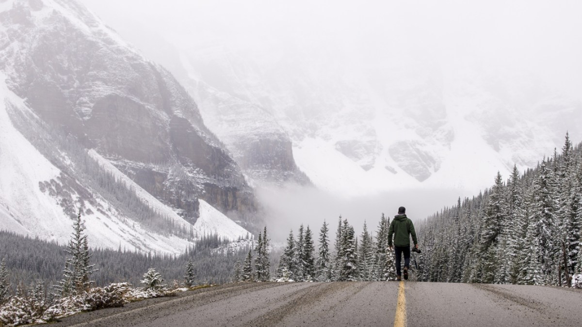 WEB—Photographer-walks-down-a-road-in-the-winter-with-his-camera—shutterstock_499404463