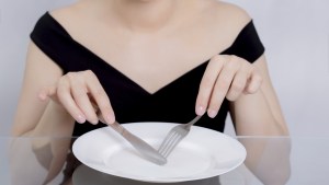 Femme devant une assiette vide