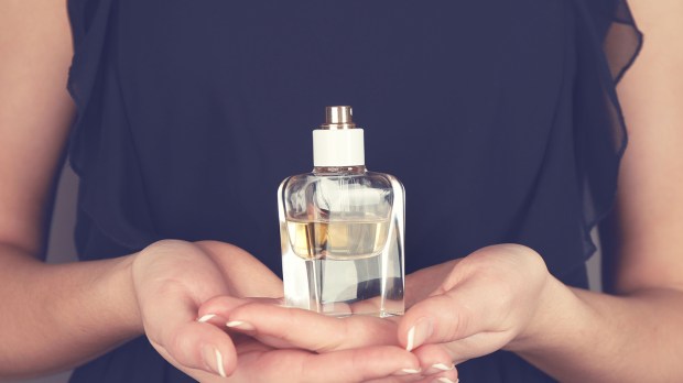 Femme offrant une bouteille de parfum