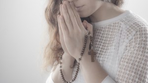Femme priant avec un chapelet