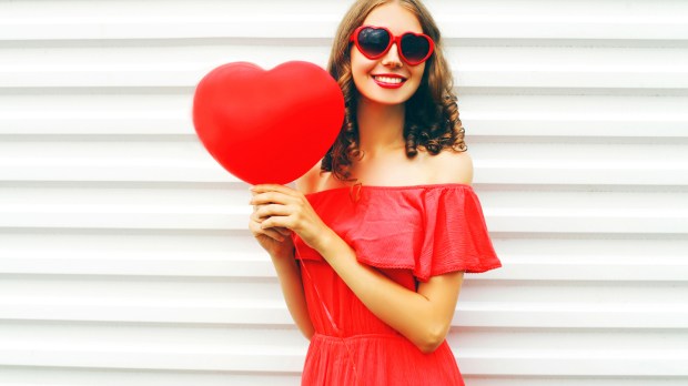 Femme habillée en rouge et tenant un coeur