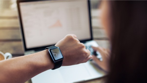JEUNE FEMME QUI REGARDE SA MONTRE