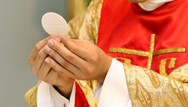 PRÊTRE TENANT UNE EUCHARISTIE