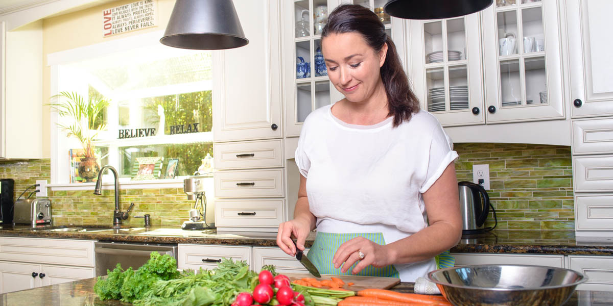 WEB3 WOMAN COOKING KITCHEN ISLAND FOOD SALAD HEALTHY Shutterstock