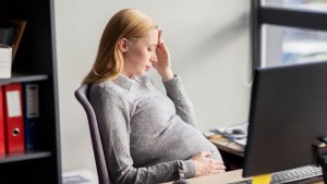 WEB3-WOMAN-HEADACHE-OFFICE-PREGNANCY-PREGNANT-WORK-shutterstock_497312980-By Syda Productions-AI