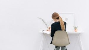 JEUNE FEMME DEVANT UN BUREAU