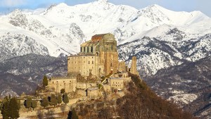 WEB – CUP001 – The Sacra di San Michele, the symbol of the Italian region of Piedmont, stands in the dawn. In the background are visible mountains of the Val di Susa – shutterstock_640285153