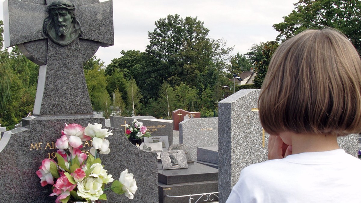 PETITE FILLE PRIANT AU CIMETIERE