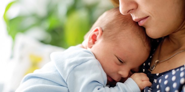 NEWBORN SNUGGLING WITH MOTHER