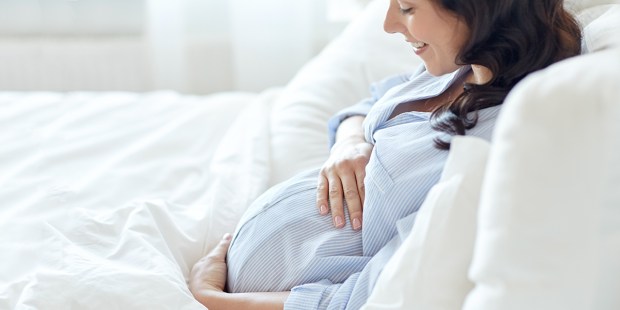 PREGNANT WOMAN LYING IN BED