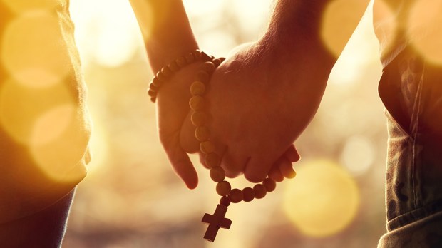 Le  chapelet Web3-couple-praying-together-holding-rosary-in-hand-shutterstock_1176450760