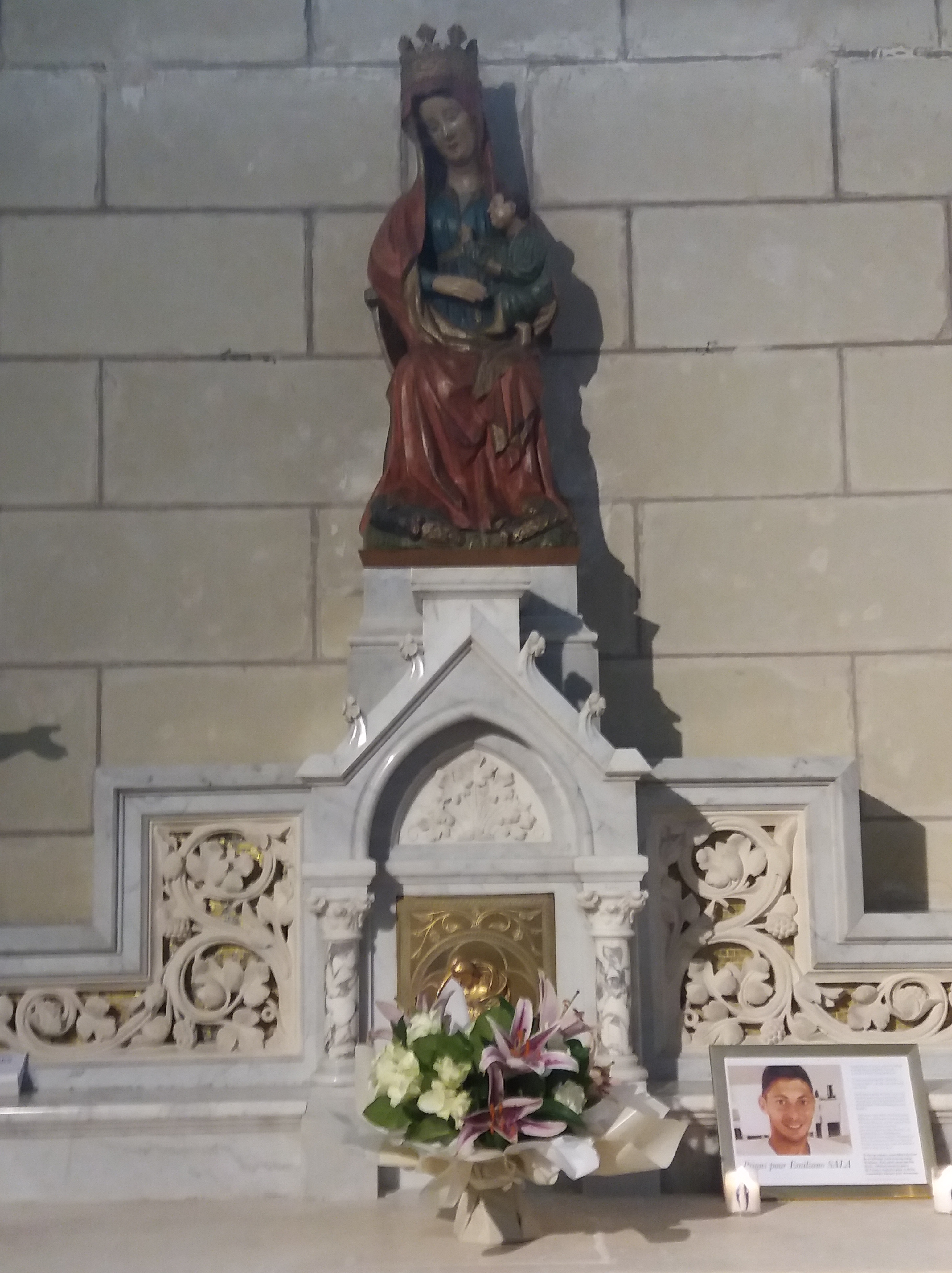Notre-Dame La Blanche, église de Carquefou (Loire-Atlantique). Un portrait du footballeur du FC Nantes a été déposé au pied de la statue.
