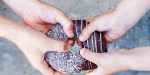 children's hands holding a chocolate donut. two kids pull to themselves donut. closeup.the concept of sharing food