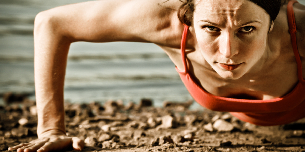 web3-Strong-woman-doing-pushup-at-the-beach