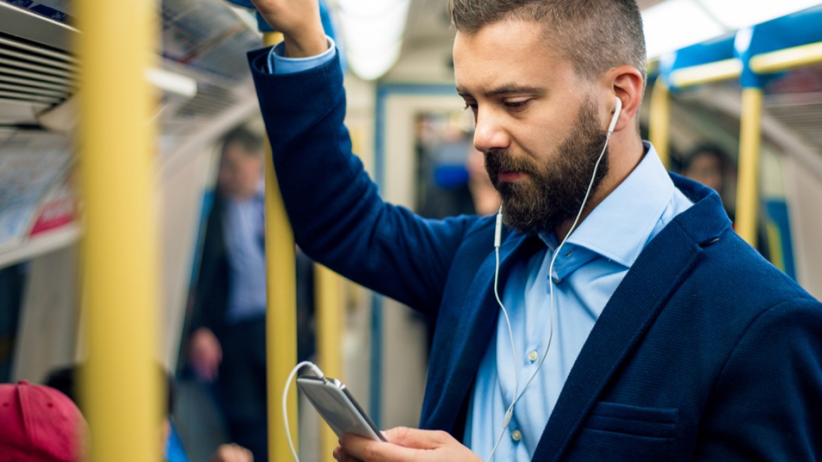 Jeune homme lisant dans le métro