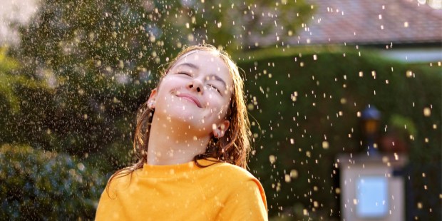 Ces petits riens qui nous mettent en joie dans notre quotidien... - Page 2 WEB3-Happy-smiling-teenage-girl-enjoying-rain-and-sun-putting-her-face-under-water-drops-Shutterstock_1542223286