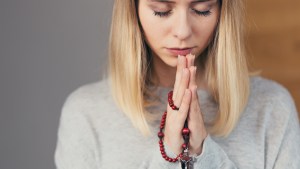 Kobieta modli się na różańcu