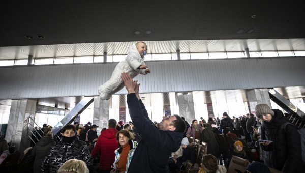 Ojciec podrzuca dziecko na dworcu