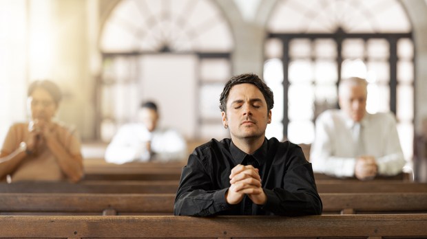 Dieu à tu et à vous. Faut-il vouvoyer ou tutoyer le Seigneur ? Religious-and-young-man-in-church-with-congregation-faithful-and-hands-together-shutterstock_2224925891