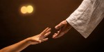 Jesus Christ reaching out to help those in need in a room lit with warm lights