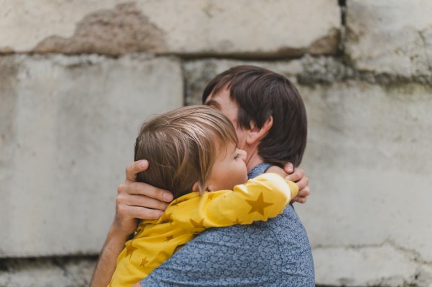 man dad having quality time with their kid son boy six year old hug on arms happy father playing together with child real life authentic day to day fatherhood moments