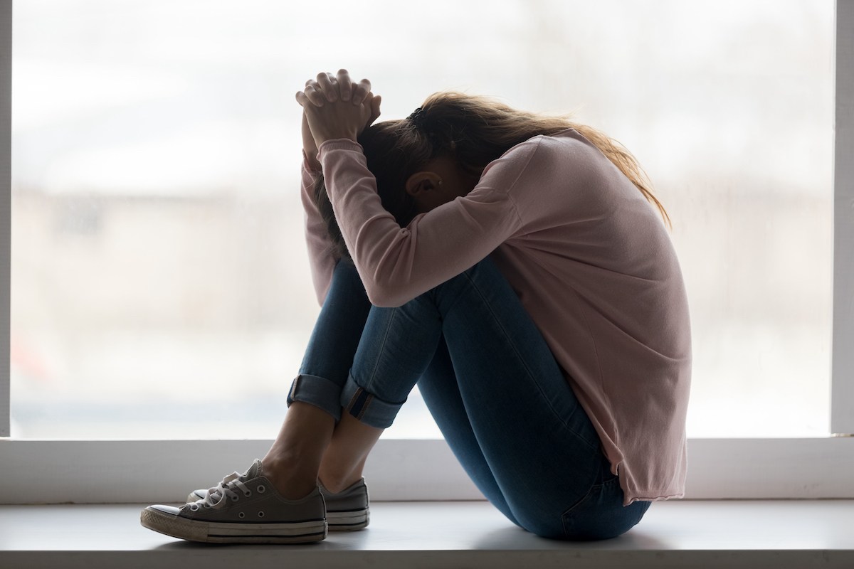 Depressed sad teen girl sit on sill crying alone at home upset desperate young woman feeling frustrated anxious regret mistake suffer from unwanted teenage pregnancy abortion problem concept