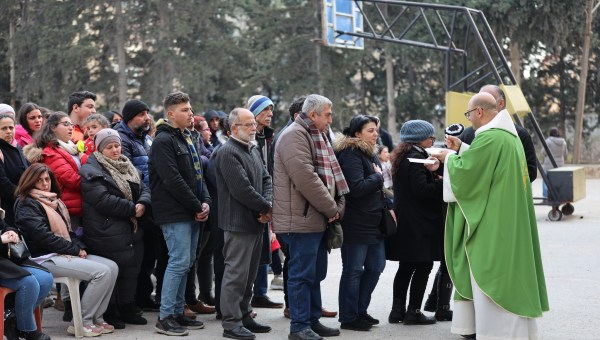 Fr._Samhar_Ishak_ofm_gives_Communion_to_Aleppo_displaced_people._Aleppo_-_Terra_Sancta_School_.jpeg
