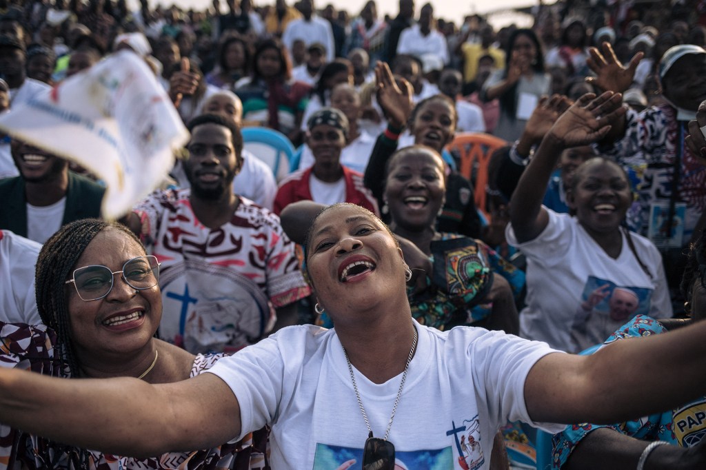 A woman cheers as attendees gather ahead of the arrival of Pope Francis for the mass at the N'Dolo Airport in Kinshasa