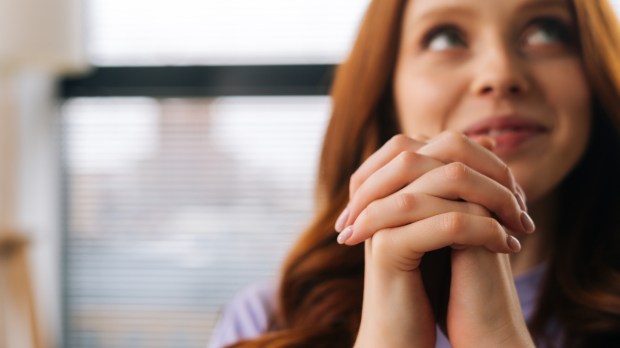 kobieta podczas modlitwy uwielbienia spogląda w górę i uśmiecha się radośnie