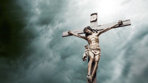 Jezus Chrystus na krzyżu na tle zachmurzonego nieba