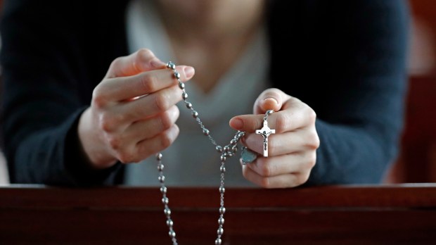 mujer rezando el rosario