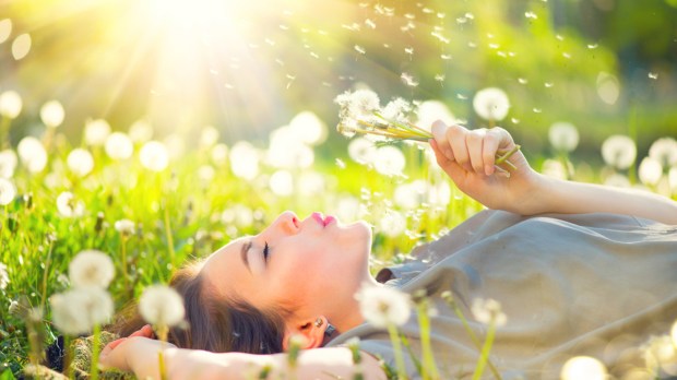 Mulher deitada no campo em dia de sol