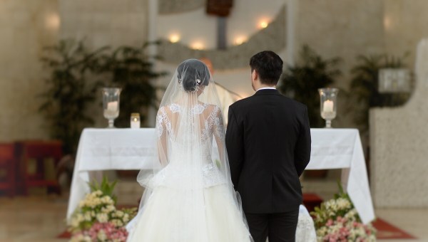 Bride and groom before altar with backs to camera